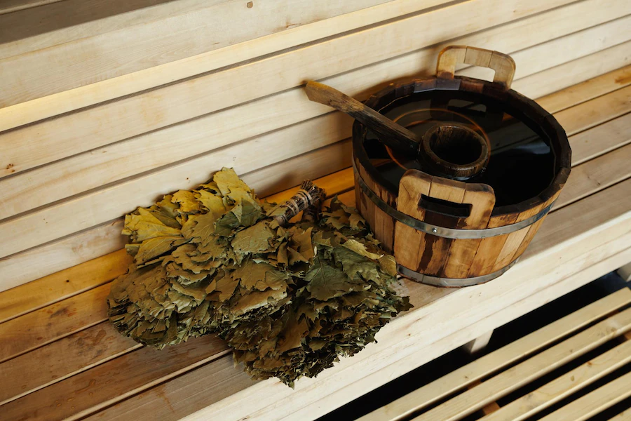 sauna-bucket-full-water-with-ladle-broom-wooden-bench_153608-6523.jpeg